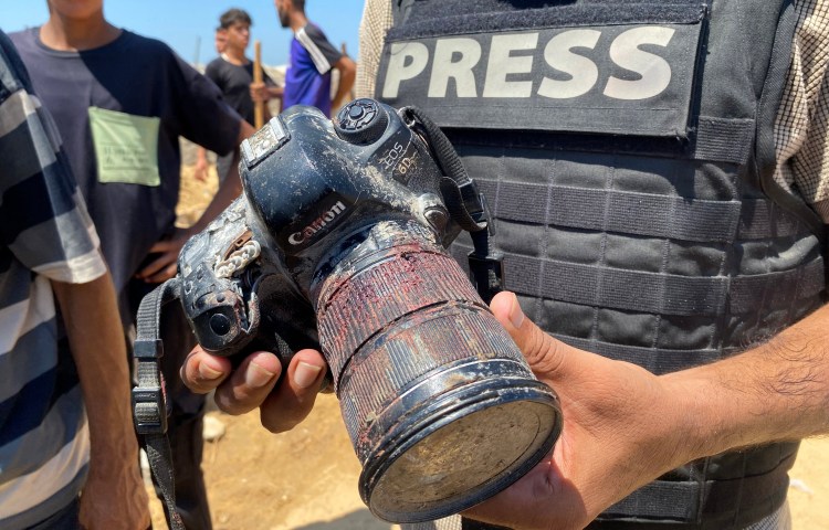journalist holding blood-stained camera