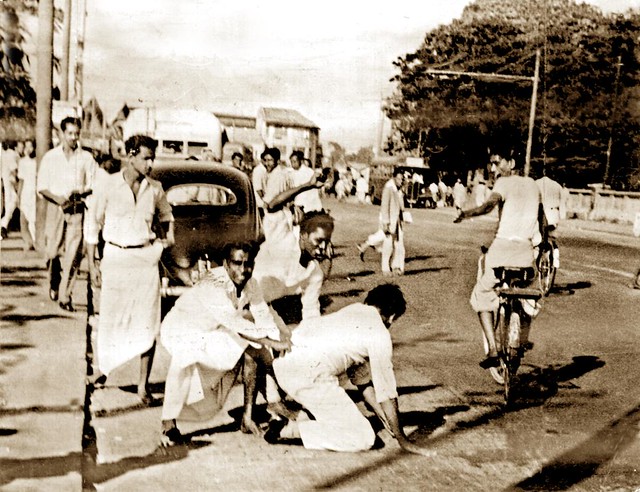 Photograph: A Sinhalese mob beats a Tamil passenger after pulling him out of his car. 1958. (Courtesy Victor Ivan)